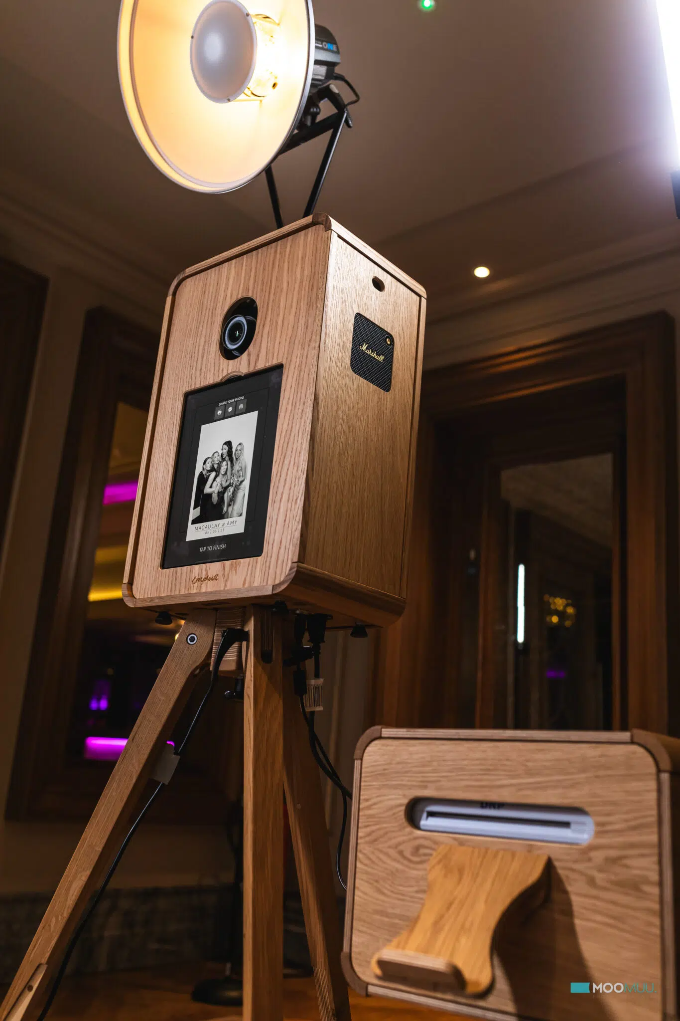 Close view of the MooMuu ICON Booth’s oak housing, camera and portrait screen at an indoor event.
