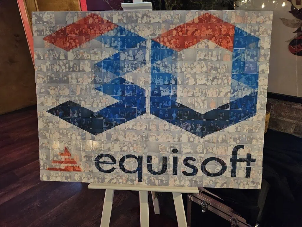 A large sign displays the Equisoft logo and the number 30, created as a mosaic from many small photos of people, celebrating the company’s 30th anniversary at a corporate experiential event. The sign is set on an easel indoors.