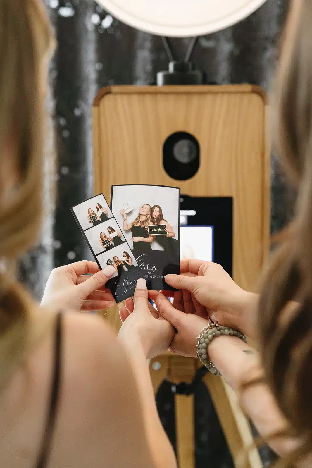 Guests holding their printed photographs beside the MooMuu ICON Booth.