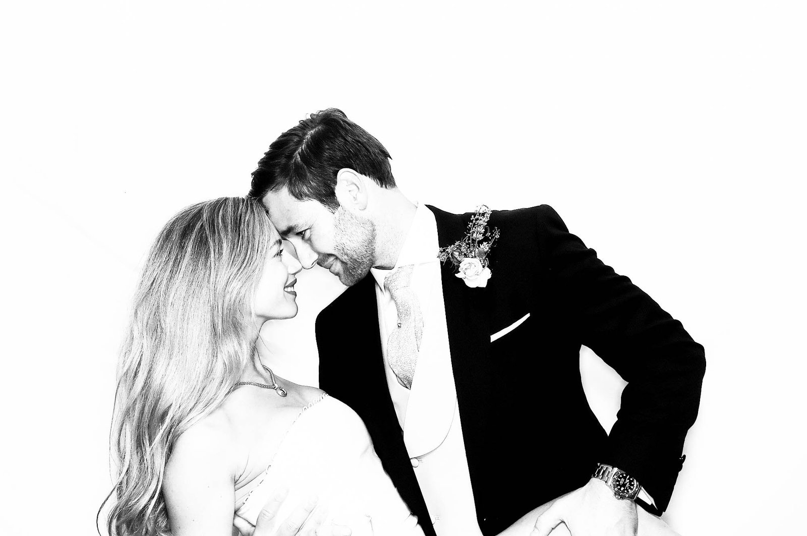 A bride and groom smile and lean their foreheads together, gazing at each other lovingly. Perfect for sketch bot hire or draw me bot hire at your next corporate event experiential. The groom wears a suit with a buttonhole; the bride, a strapless dress.