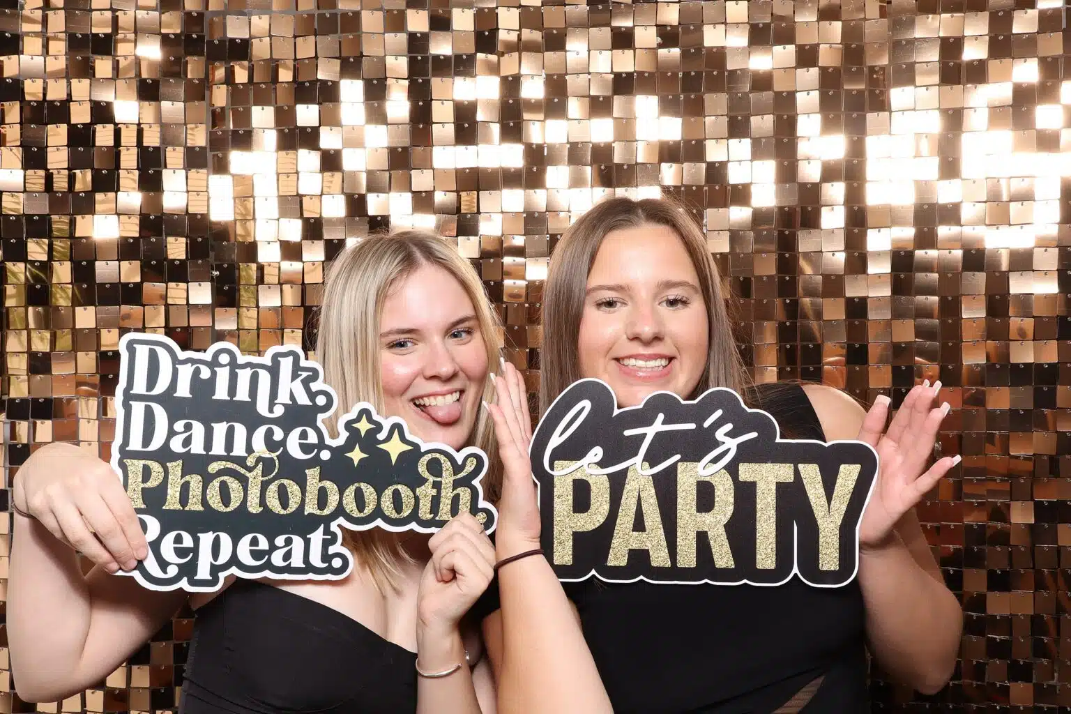 Wedding guests posing with playful props at a MooMuu photo booth.