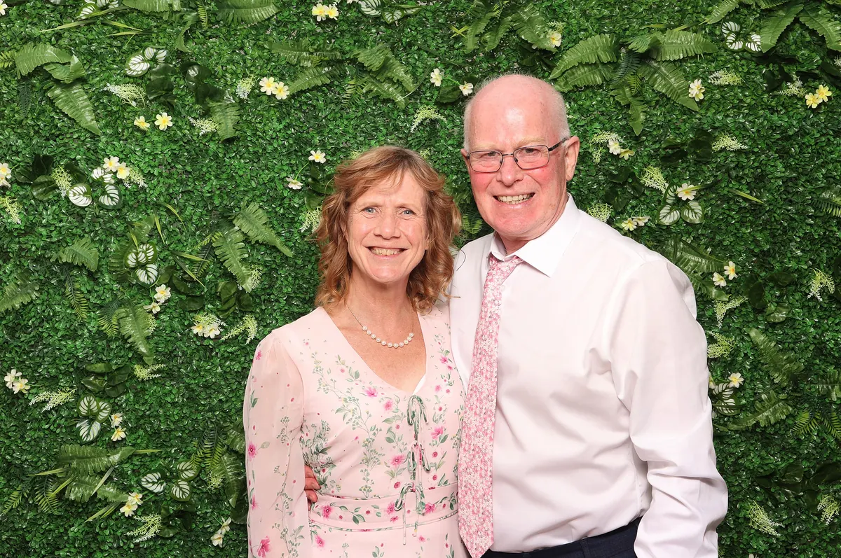 Celebration guests posing together in front of a foliage backdrop